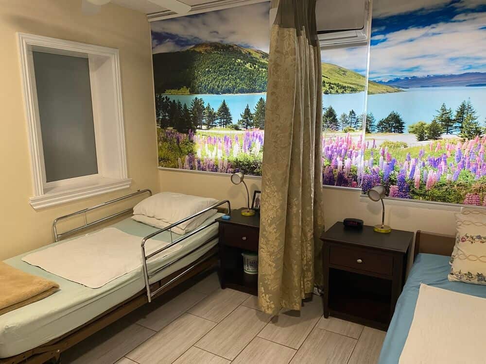 Shared bedroom in the cacayorin care home. Desks for each patient and large space in between the hospital beds