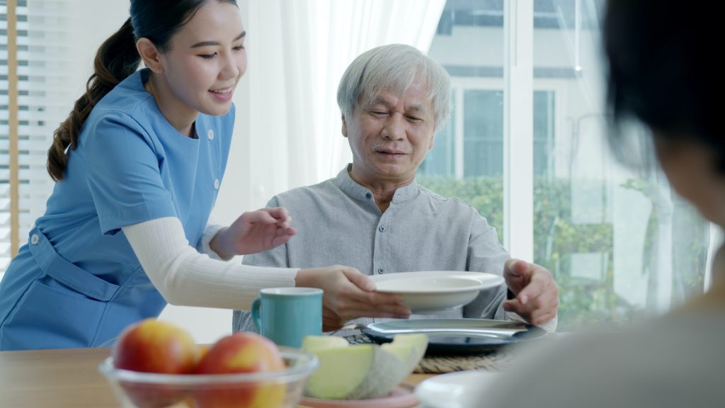 Attractive young senior asian citizen couple happy sit, talk, eat soup for healthy nutrition