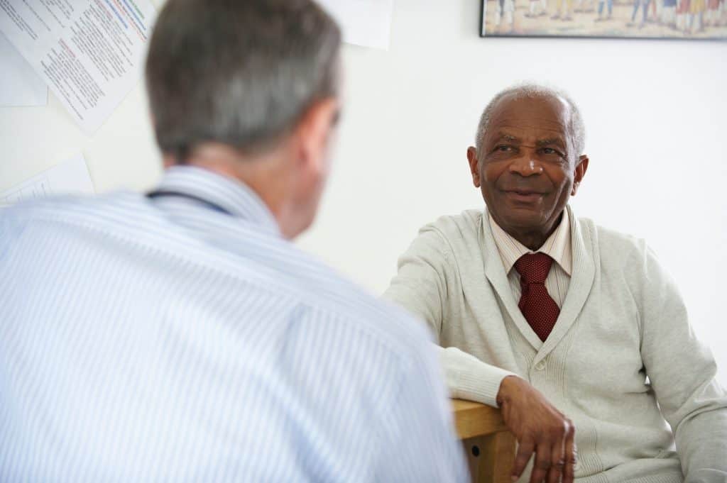 Elderly black man talking to doctor